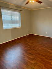 Unfurnished room featuring ornamental molding, visible vents, and wood finished floors