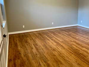 Unfurnished room with visible vents, a textured ceiling, baseboards, and wood finished floors