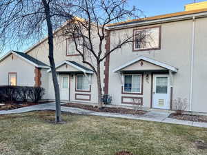 View of property featuring a front lawn and stucco siding