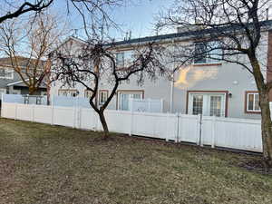 View of side of home with a yard, a fenced front yard, a gate, and stucco siding