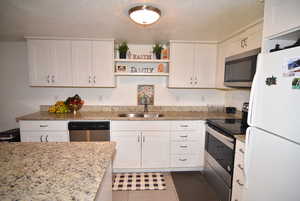 Downstairs Kitchen with stainless steel appliances, open shelves, SS sink, and white cabinetry