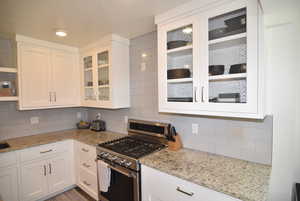 Kitchen featuring, gas stove, and white cabinets