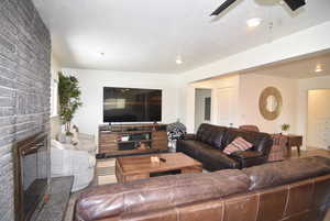 Great room area with a textured ceiling, and fireplace.