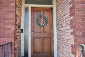 Doorway to property featuring brick siding