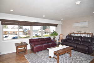 Living area featuring a textured ceiling, recessed lighting, hardwood finished floors.