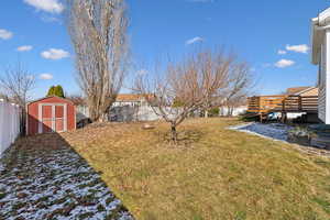 View of yard with a shed, a fenced backyard, and an outbuilding