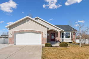 Ranch-style house featuring a garage, driveway, fence, and brick siding