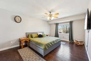 Bedroom with a ceiling fan, baseboards, and hardwood / wood-style floors