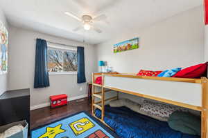 Bedroom with visible vents, ceiling fan, baseboards, and wood finished floors