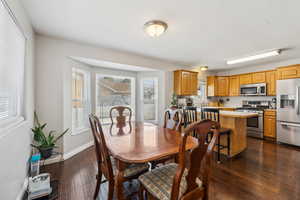 Dining room with dark wood-style floors and baseboards