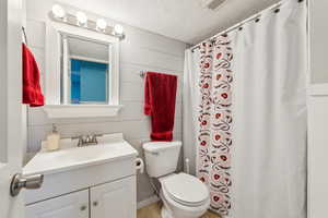 Bathroom featuring toilet, tile patterned floors, visible vents, vanity, and a shower with curtain