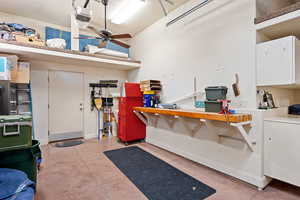Garage with baseboards, a garage door opener, and a workshop area