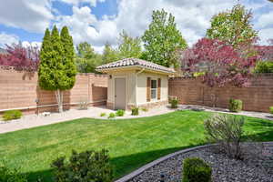 View of yard with a fenced backyard, a shed, and an outbuilding