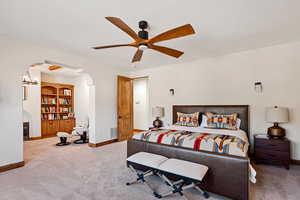 Bedroom featuring carpet floors, arched walkways, baseboards, and visible vents