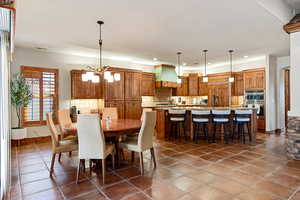Dining area featuring recessed lighting, dark tile patterned floors, baseboards, and a chandelier