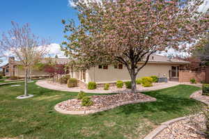 View of home's exterior with a lawn, a tiled roof, fence, and stucco siding