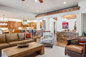 Living room with arched walkways, recessed lighting, and ceiling fan with notable chandelier