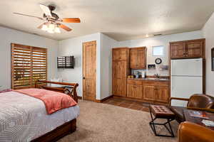 Bedroom with a sink, baseboards, freestanding refrigerator, and visible vents