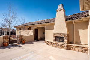 View of patio / terrace featuring an outdoor stone fireplace and a gate