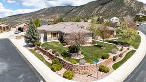 View of front of house with a tile roof, a front lawn, stucco siding, a mountain view, and driveway