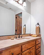 Bathroom featuring vanity, tasteful backsplash, and visible vents