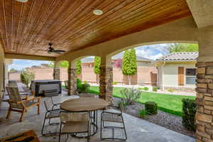 View of patio featuring a hot tub, outdoor dining area, a ceiling fan, and a fenced backyard