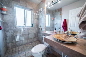 Bathroom with a sink, a shower stall, and toilet