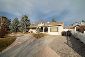 View of front facade with fence, a mountain view, and stucco siding