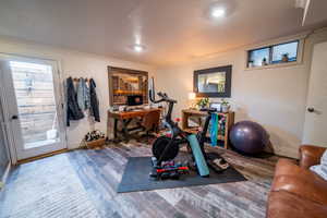 Workout room with crown molding, baseboards, and wood finished floors