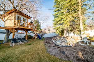 View of yard featuring a fenced backyard, a deck, and a tree house