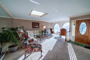 Living area with a skylight and crown molding