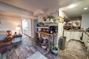 Kitchen featuring a large fireplace, crown molding, and wood finished floors