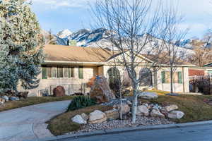 Ranch-style house featuring brick siding, a chimney, and a mountain view