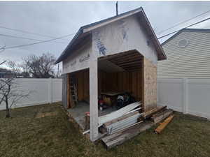 View of pole building with a fenced backyard and a yard