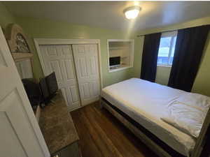 Bedroom featuring dark wood finished floors and a closet