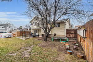 View of yard featuring a patio, a trampoline, and a fenced backyard