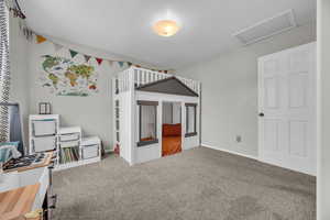 Carpeted bedroom with attic access and baseboards