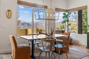 Dining area featuring a chandelier, a mountain view, baseboards, and wood finished floors