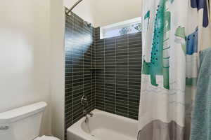 Bathroom featuring shower / tub combo and toilet