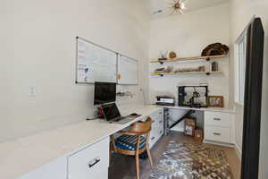 Home office featuring built in desk, wood finished floors, and visible vents