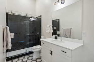 Bathroom with toilet, a shower stall, and vanity