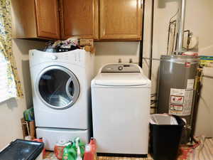 Laundry area featuring cabinet space, washing machine and dryer, and gas water heater