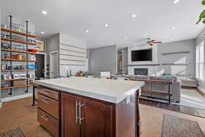 Kitchen with a center island, tile patterned flooring, light countertops, a fireplace, and recessed lighting