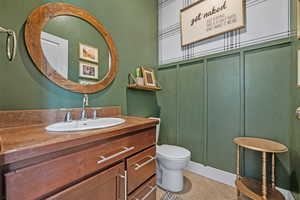 Bathroom with toilet, tile patterned flooring, and vanity