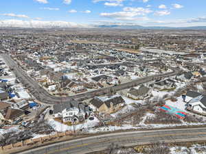 Snowy aerial view featuring a residential view and a mountain view
