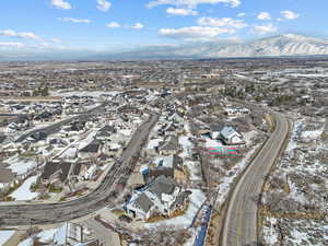 Snowy aerial view featuring a mountain view and a residential view