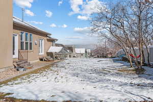 Yard covered in snow with entry steps and fence