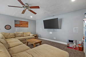 Living room featuring baseboards, visible vents, carpet, a textured ceiling, and recessed lighting
