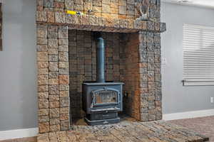 Details featuring a wood stove, baseboards, and visible vents