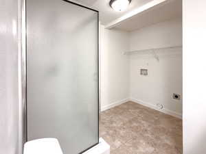 Clothes washing area featuring baseboards, laundry area, hookup for a washing machine, and hookup for an electric dryer
